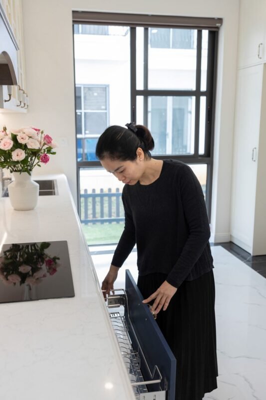Opening a dishwasher in a kitchen